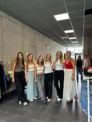 Projektgruppe mit 6 Studentinnen im sommerlichen Outfit inmitten der Flowmarkt-Stände.