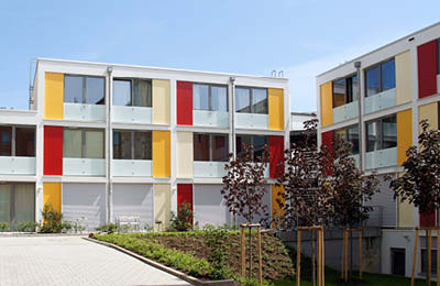 Dreistöckiges Neubau-Wohnhaus des Studierendenwerks mit Bäumen im Vordergrund