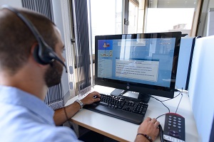 Mann mit Headset vor einem PC-Monitor im Umfrage-Labor der DHBW Mannheim übt telefonische Befragungen